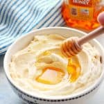 Butter with honey drizzle on a white board.