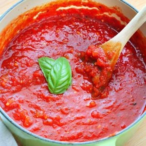 Marinara sauce in a pot with wooden spoon.