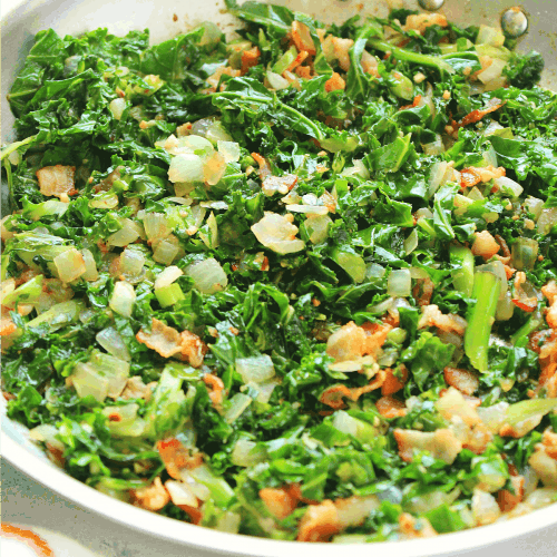 Sauteed kale with bacon in a pan.