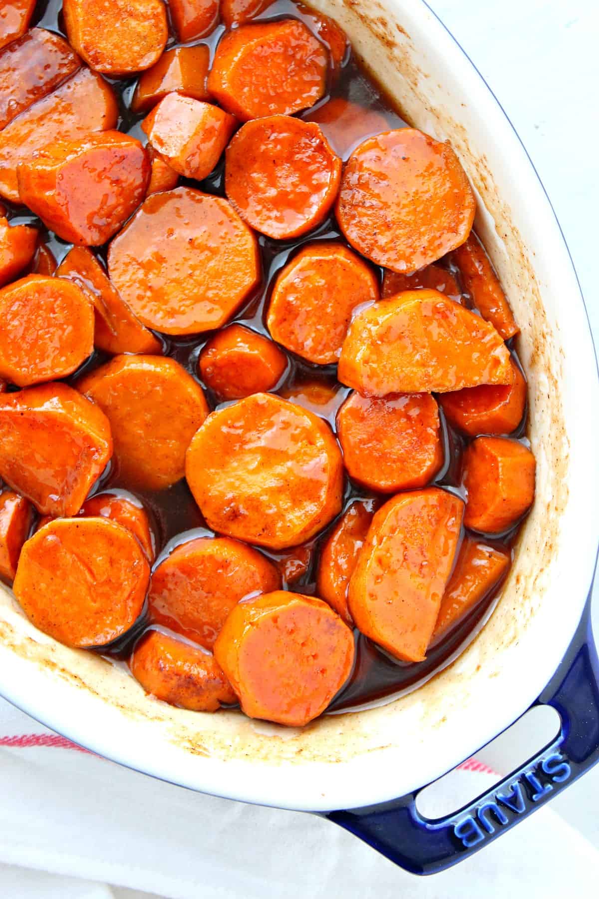 Candied cut sweet potatoes in a baking dish.