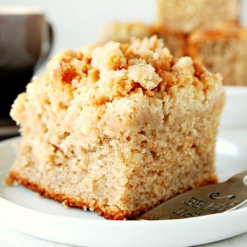 Piece of cake with crumb topping on a small plate.