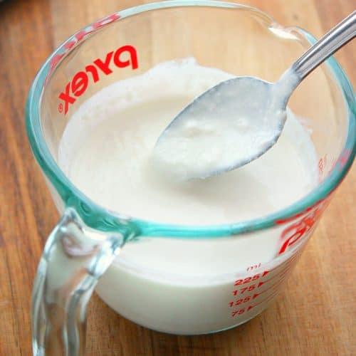 Buttermilk in a glass measuring cup.