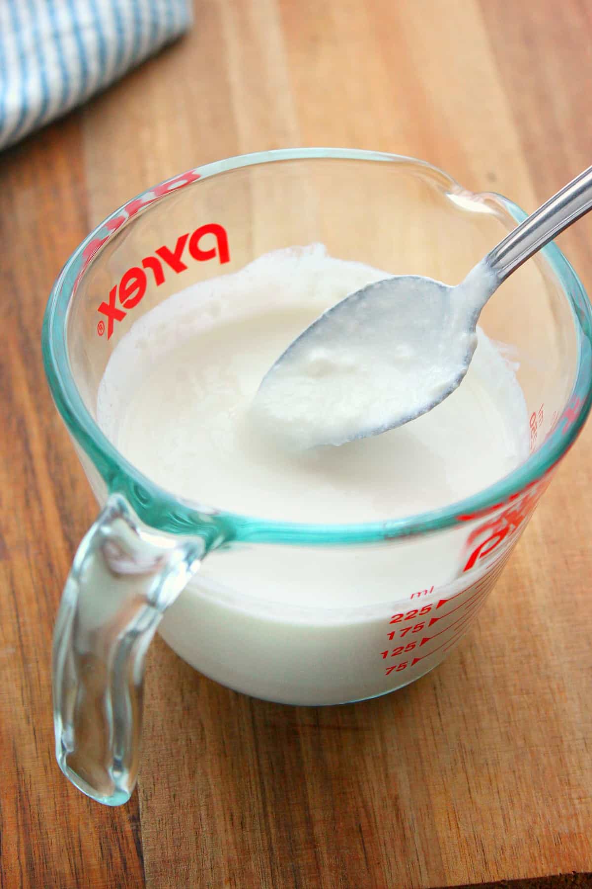 Buttermilk in a glass measuring cup.