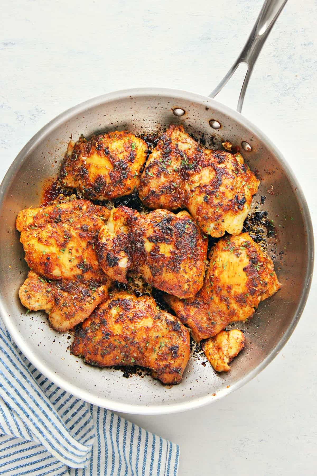 Chicken thighs in a skillet.