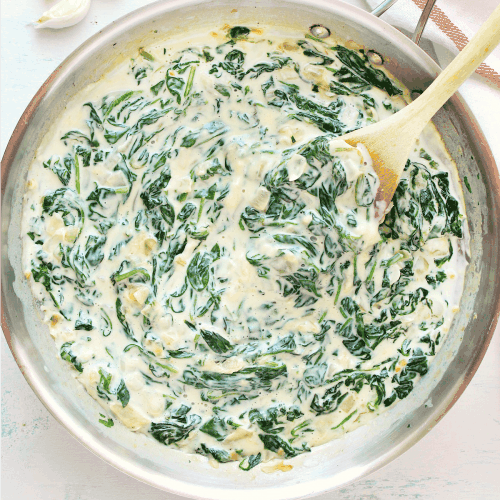 Spinach in creamy sauce in a pan.