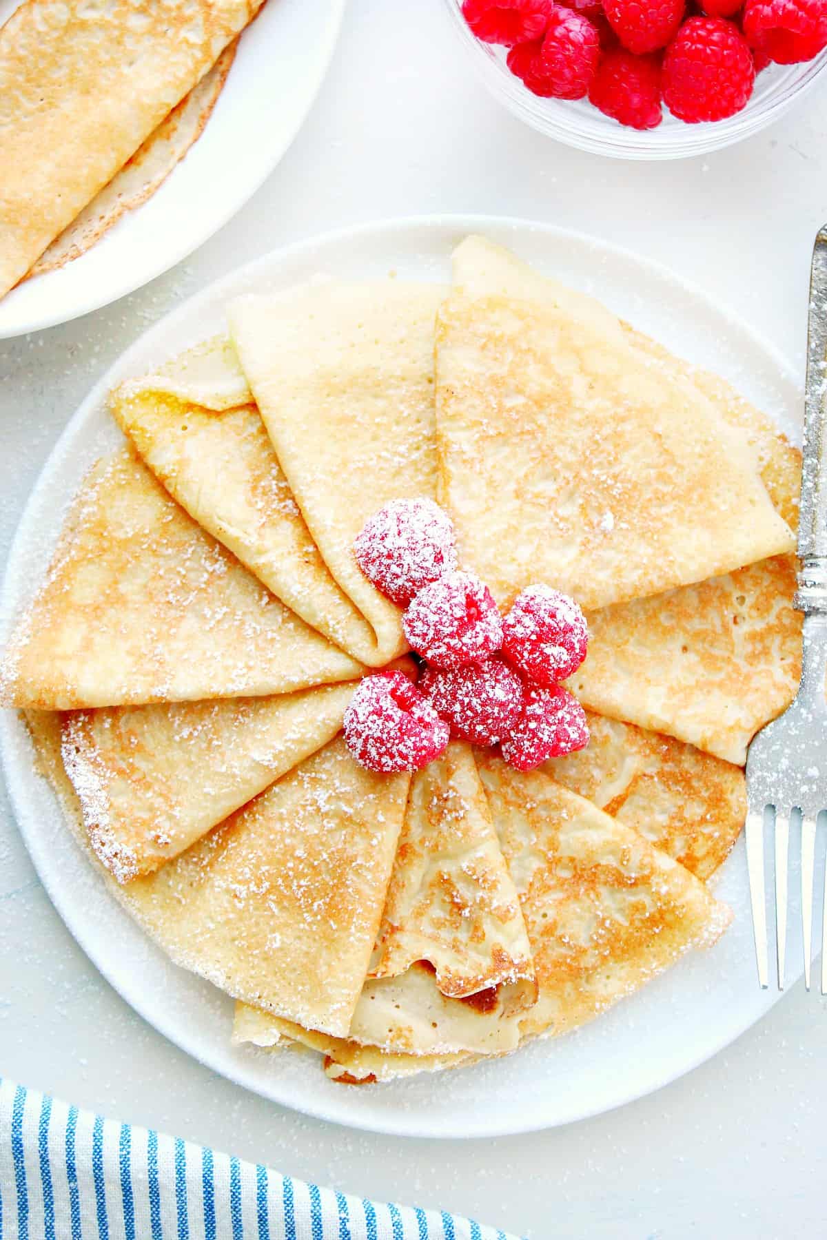 Crepes with sugar on a plate.