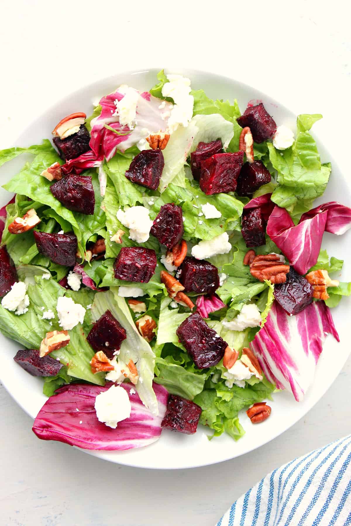 Salad with beets on a white plate.