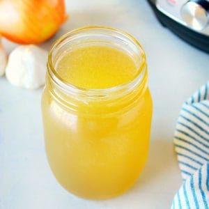 Turkey stock in a glass jar next to Instant Pot.