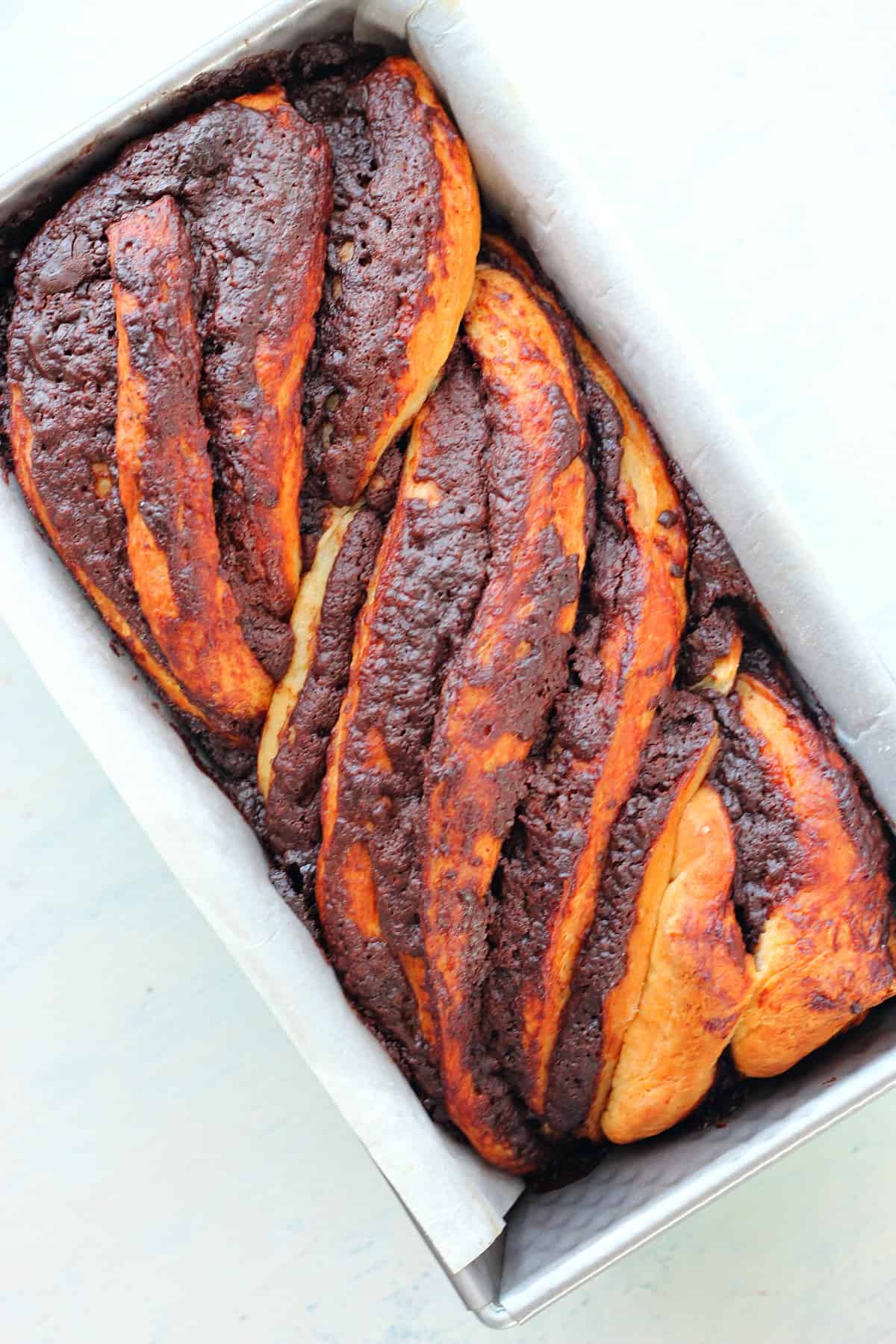 Baked chocolate babka in a loaf pan.