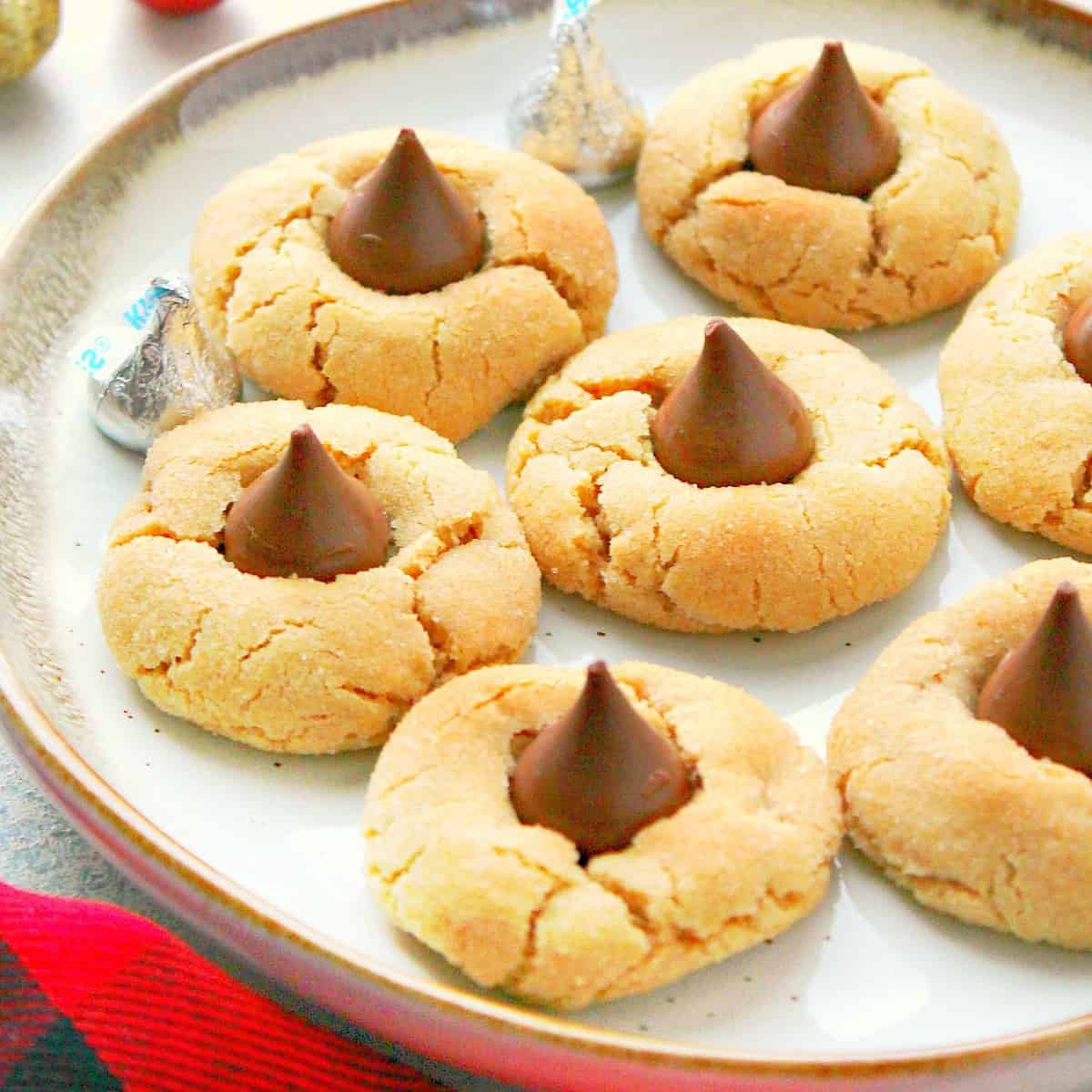 Peanut butter cookies with kisses candy on a plate.