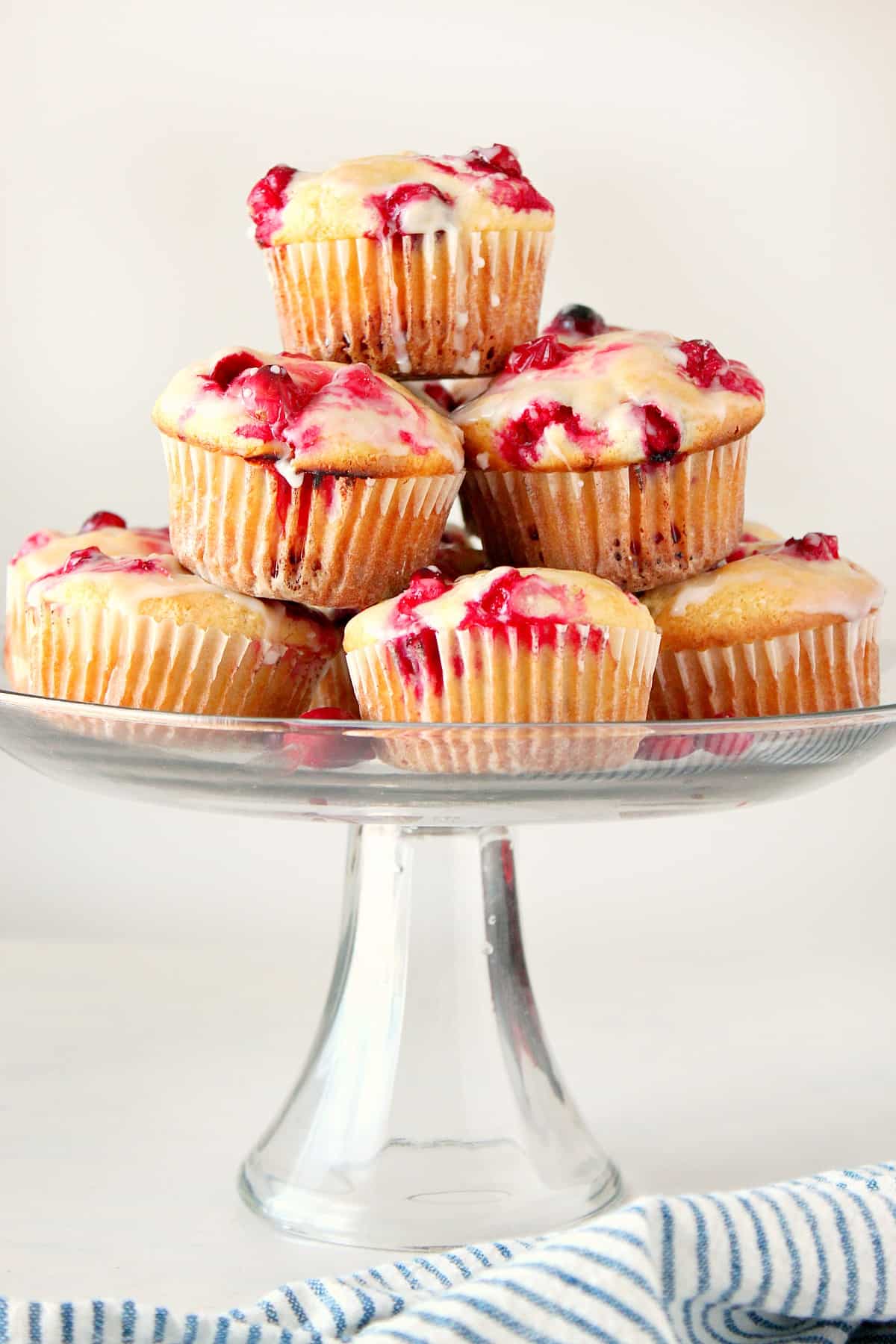 Muffins on a glass cake stand.