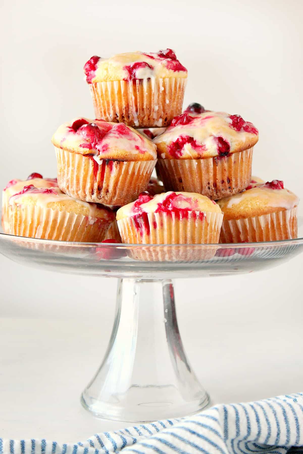 Muffins on a glass cake stand.