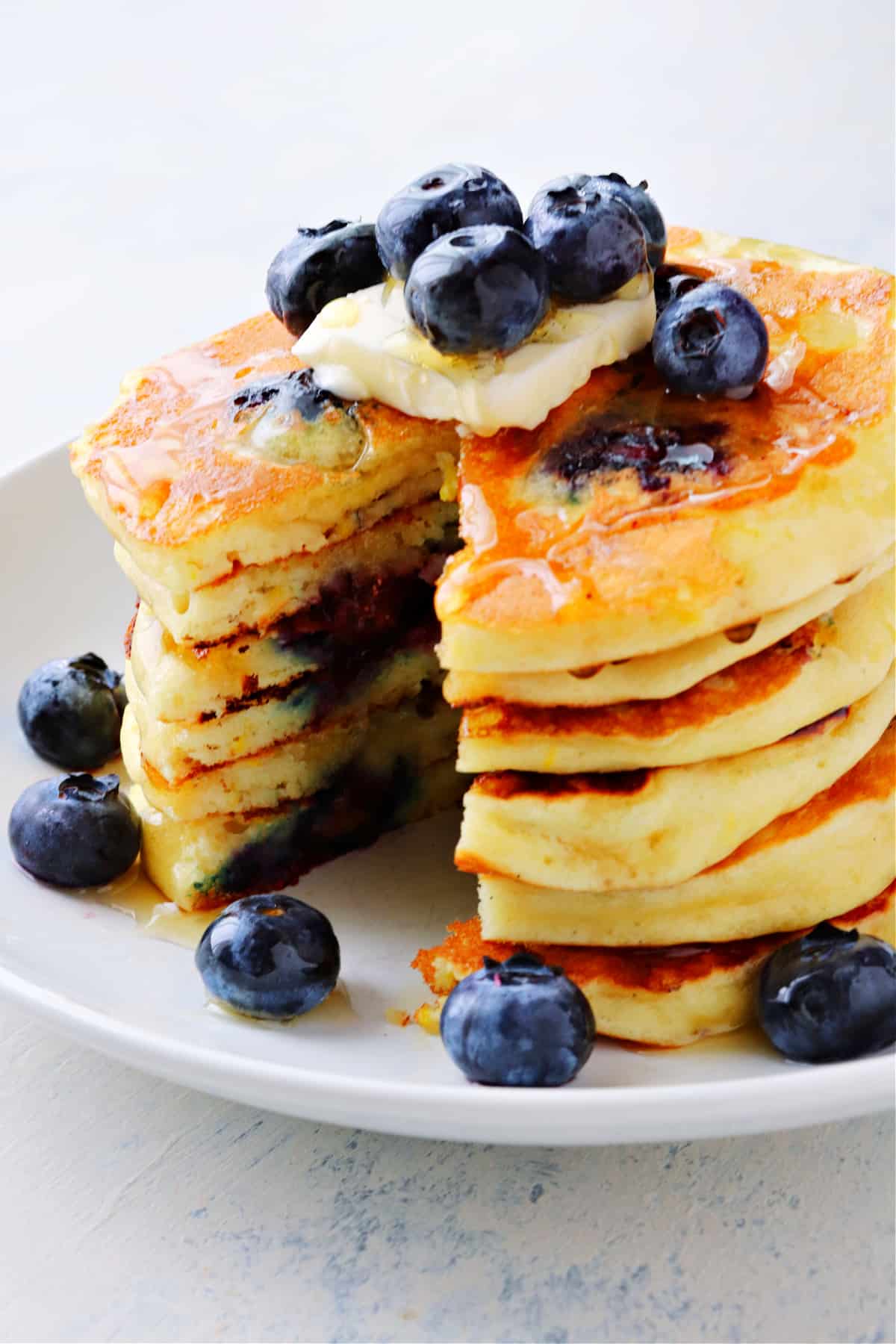 Stack of pancakes with blueberries on a plate.