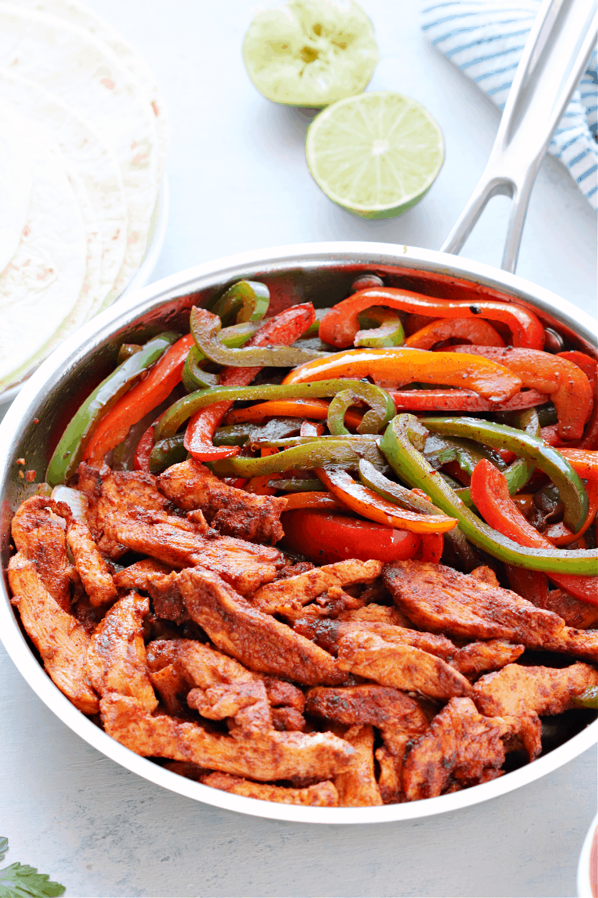 Chicken fajitas in a stainless steel skillet.