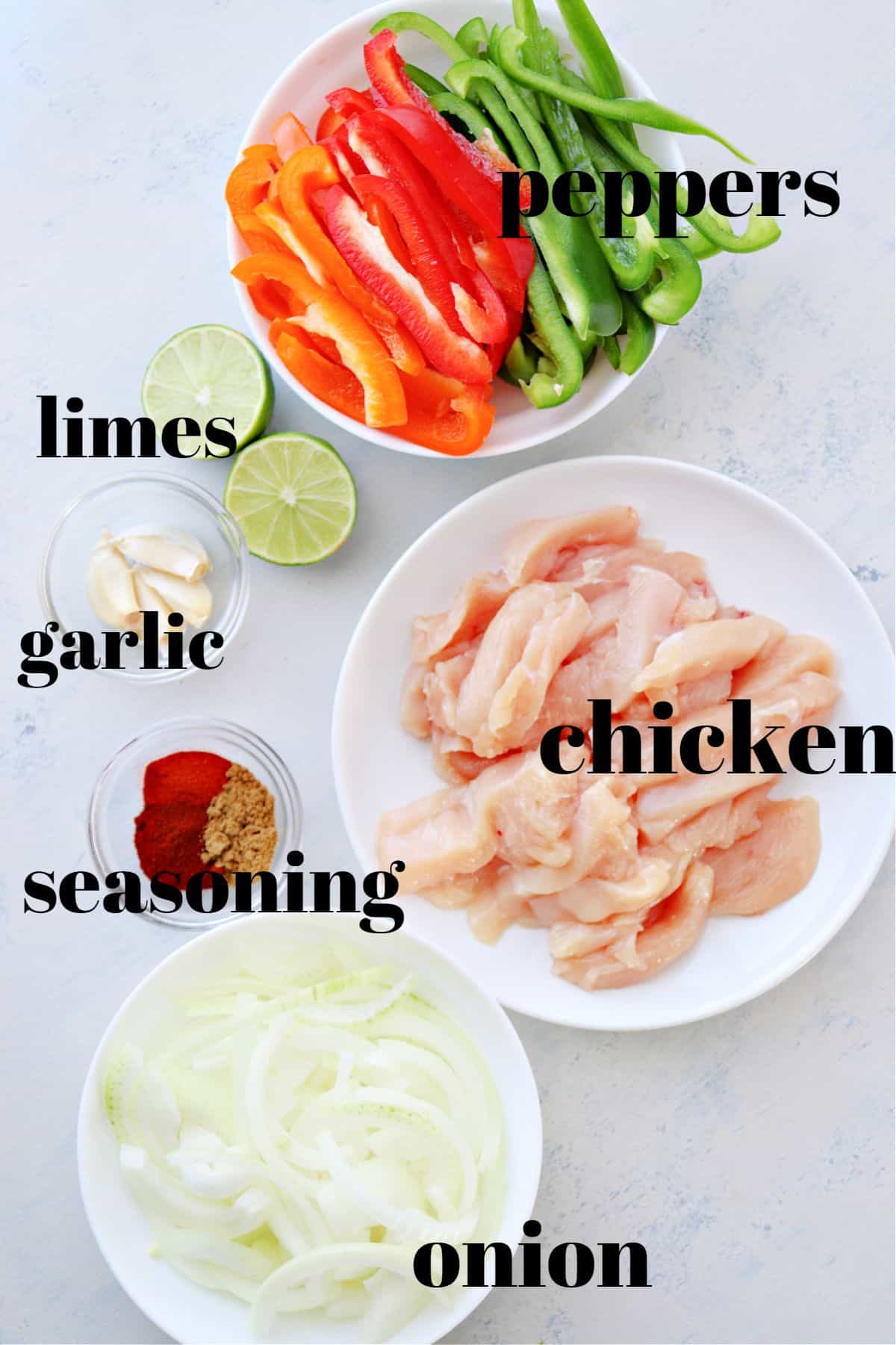 Ingredients for fajitas on a white board.