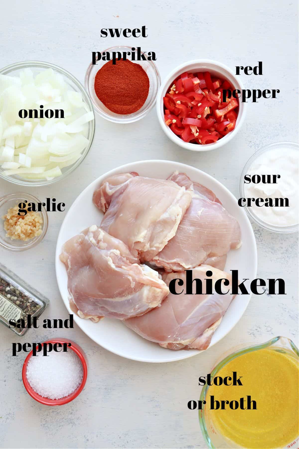 Ingredients for chicken paprikash on a board.
