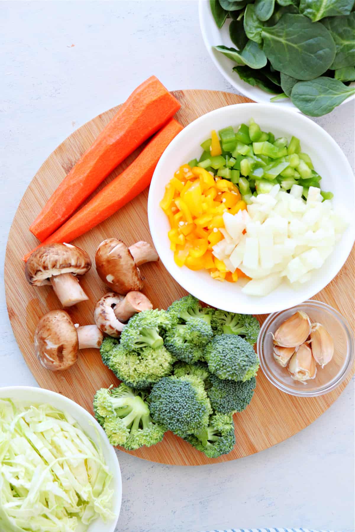 Vegetables chopped on a round cutting board.