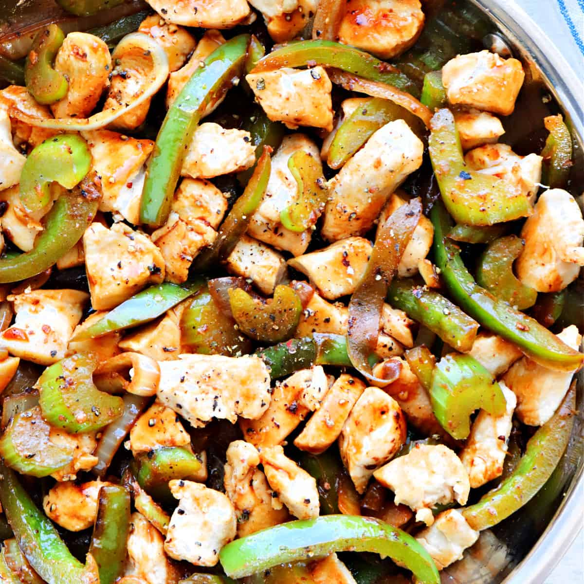 Black pepper chicken with veggies in a pan.