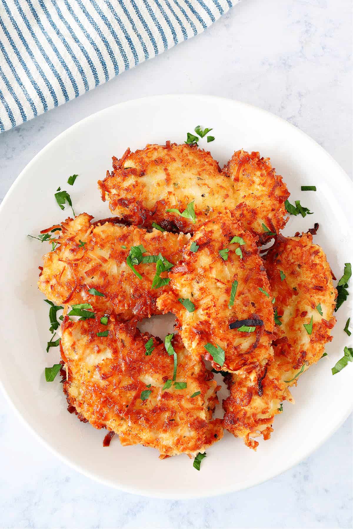 Crispy chicken with coconut on a white plate.