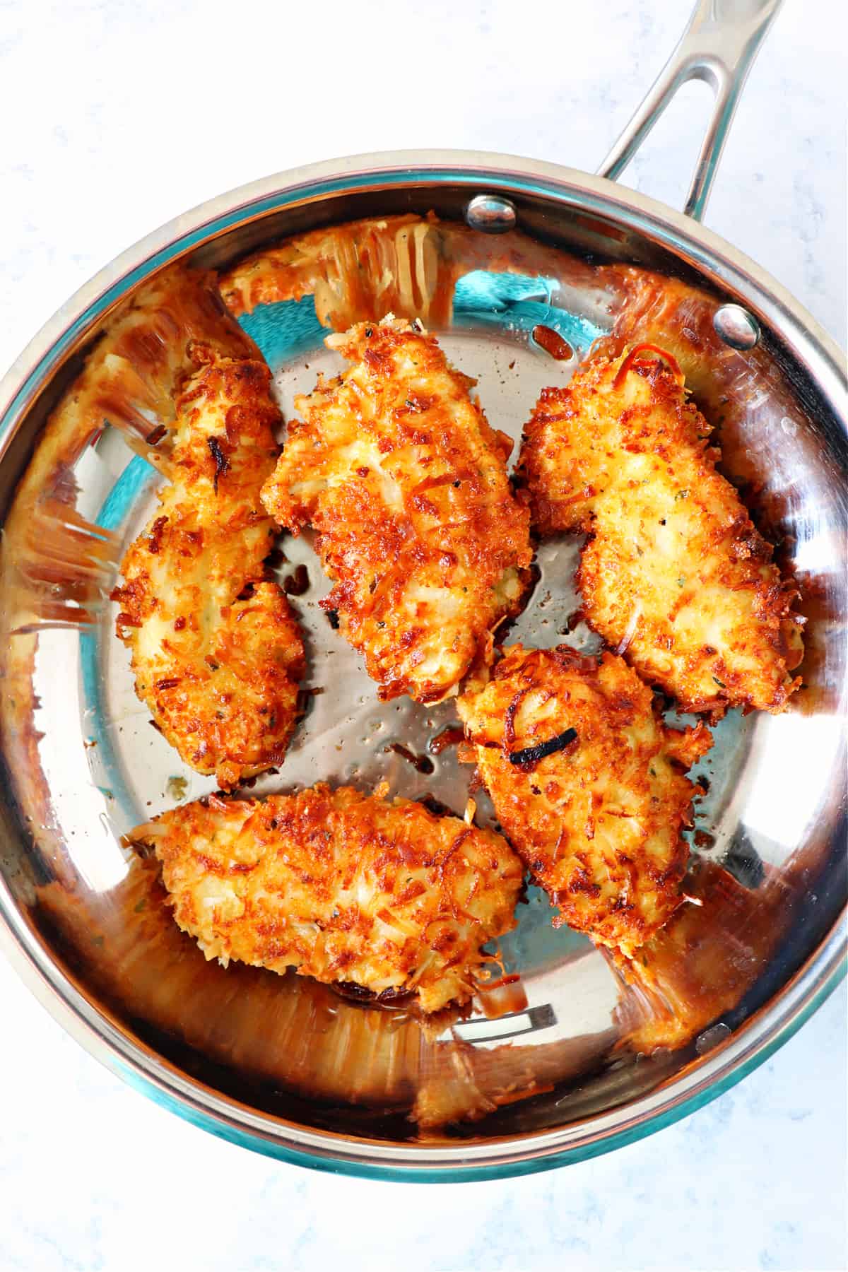 Coconut chicken in a skillet.