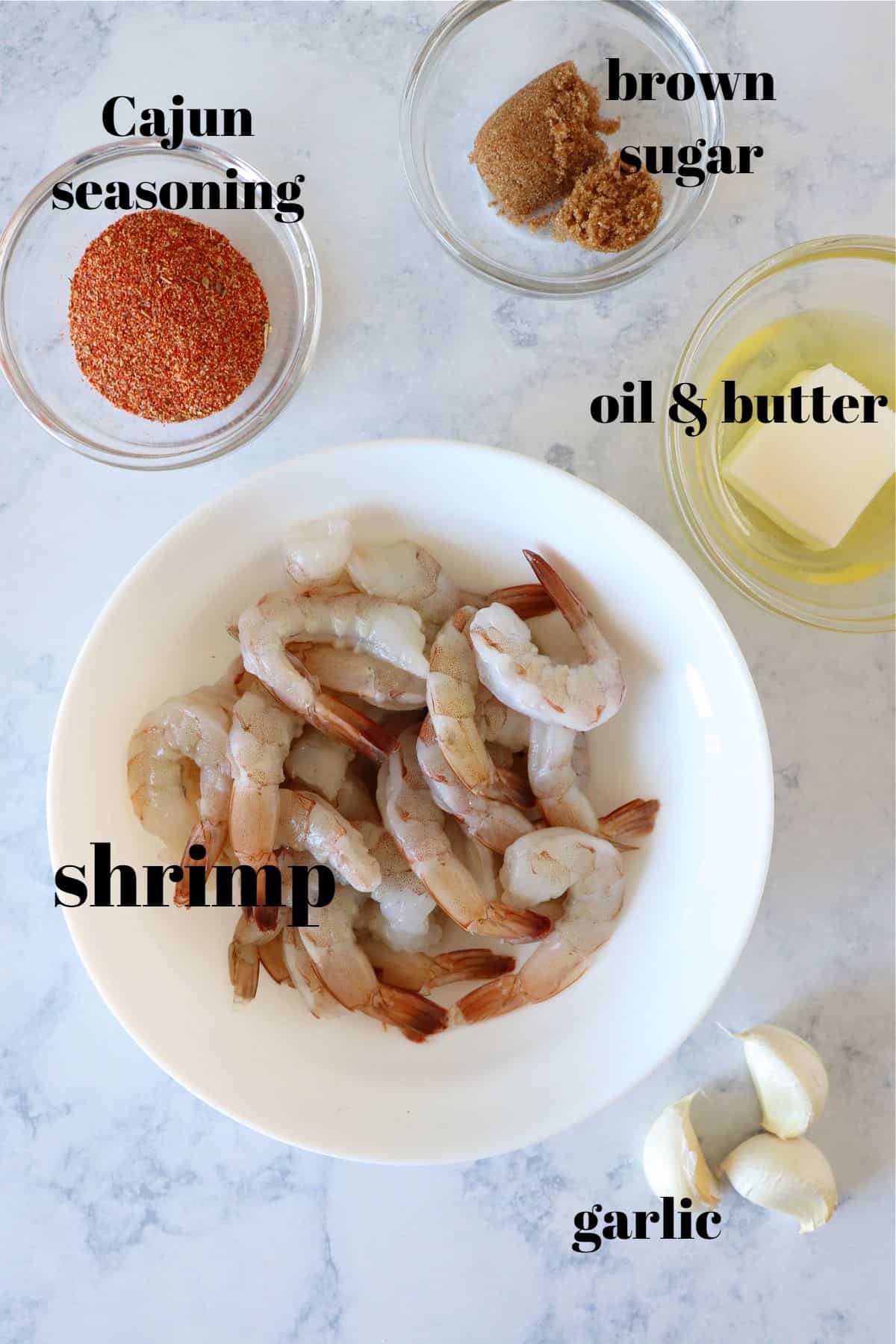 Ingredients for cajun shrimp dish on a marble board.