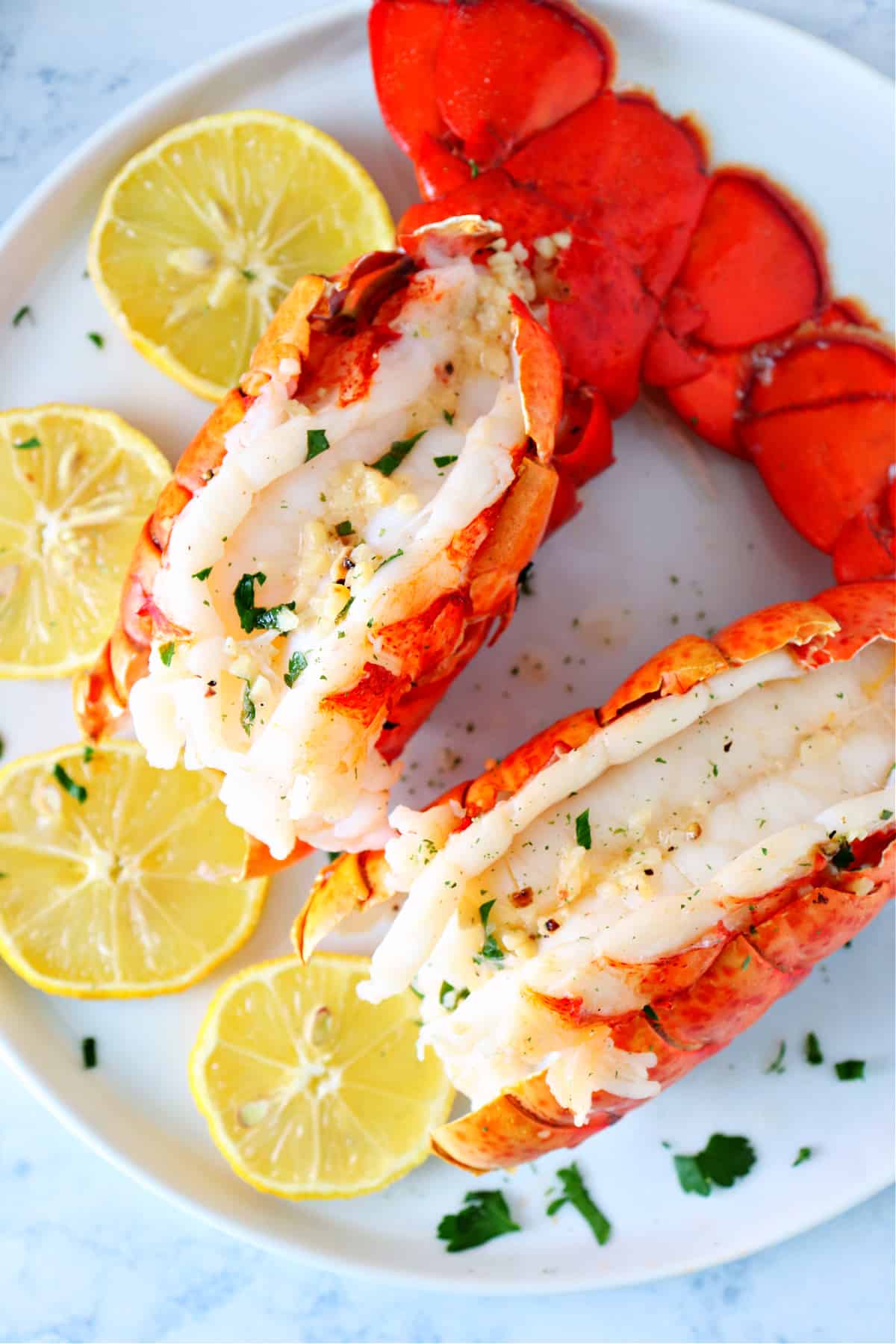 Lobster tails with lemon on a plate.