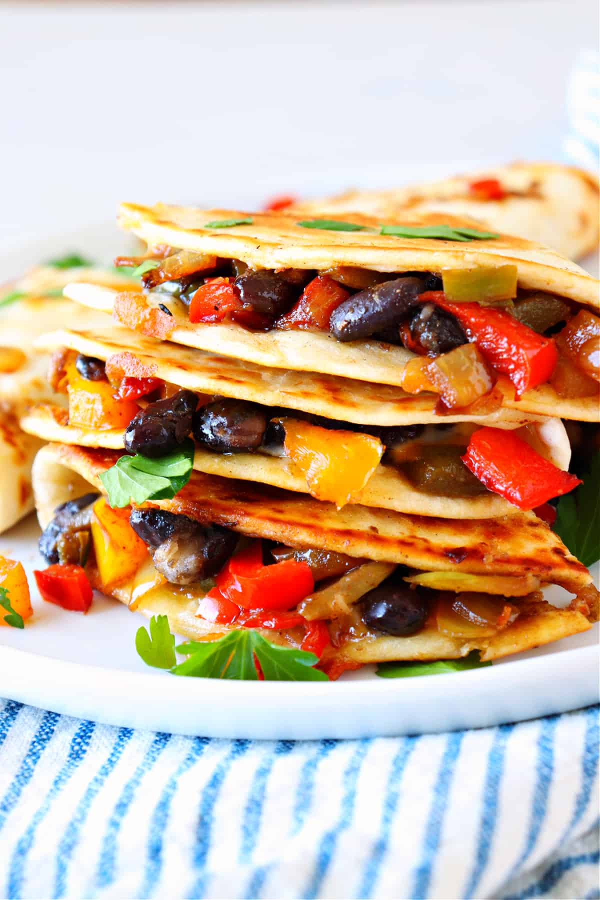 Stacked quesadillas with vegetables on a plate.