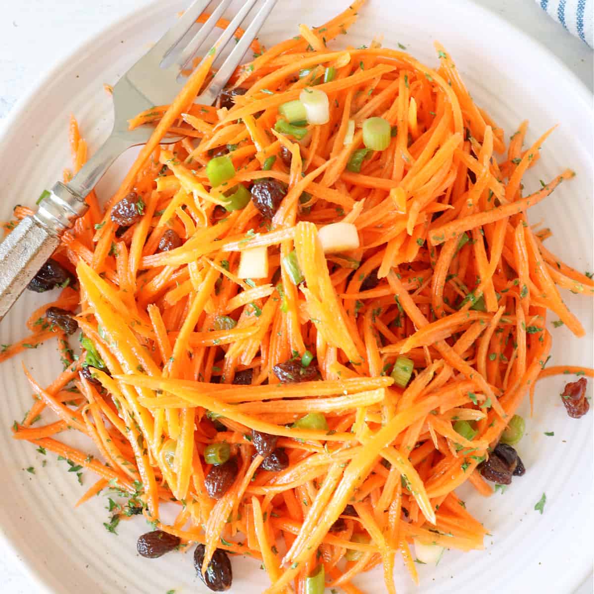 Carrot salad on a salad plate with fork.