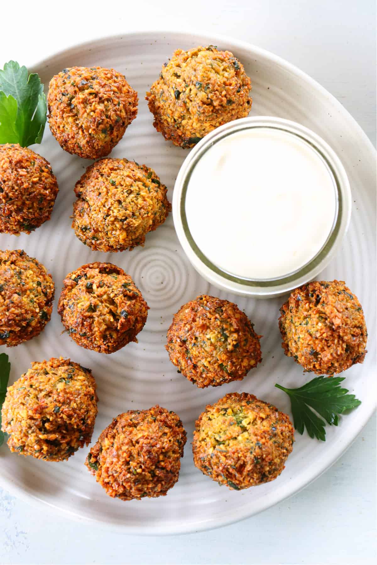 Easy Falafel Recipe Fried falafel with sauce on a plate.