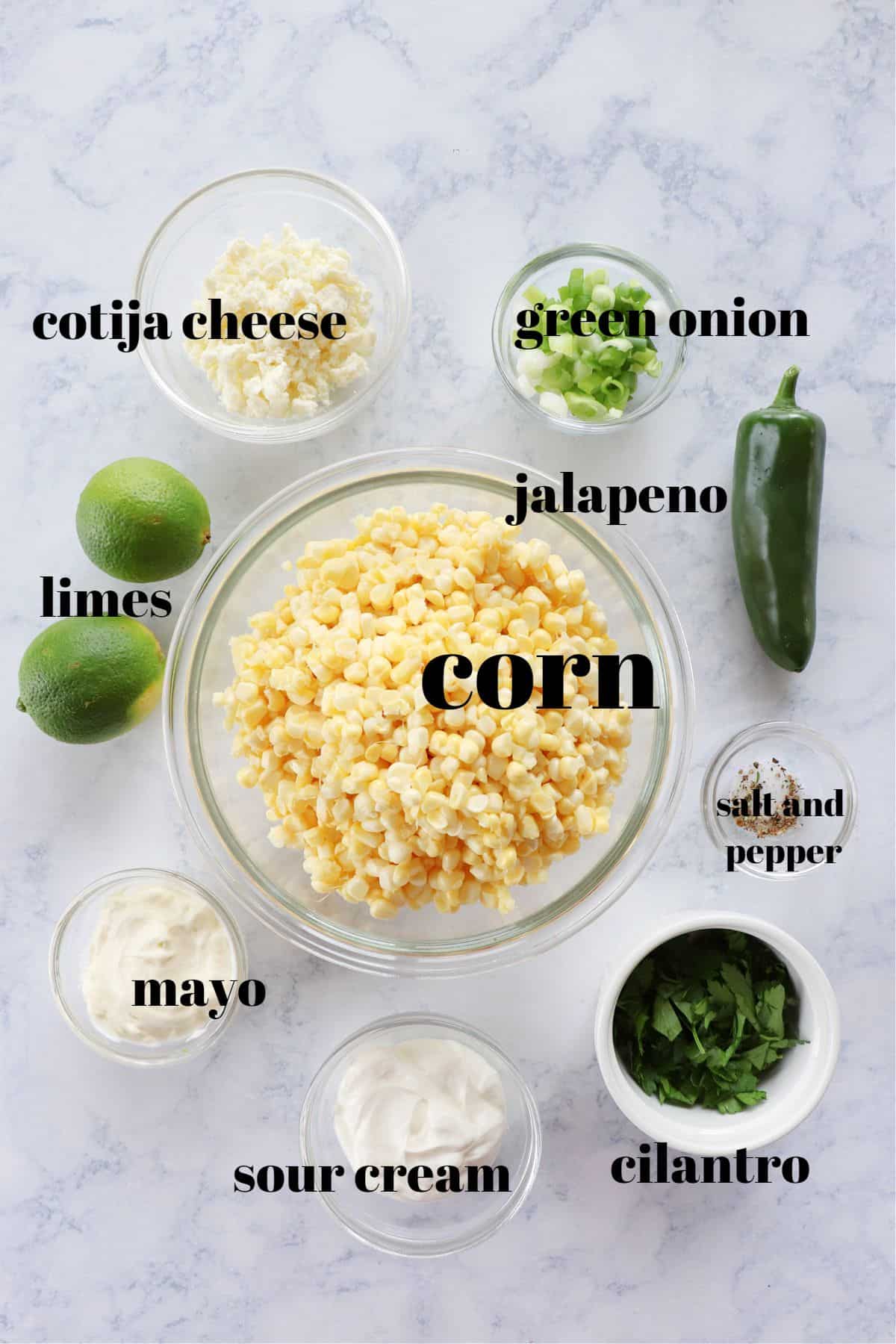 Ingredients for Mexican corn salad on a marble board.