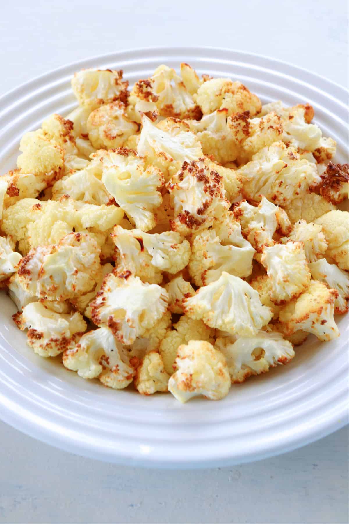 Air fried cauliflower florets on a plate.