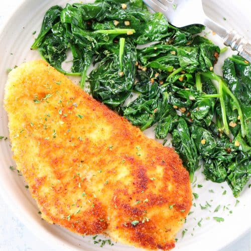 Breaded chicken and sauteed spinach on plate.