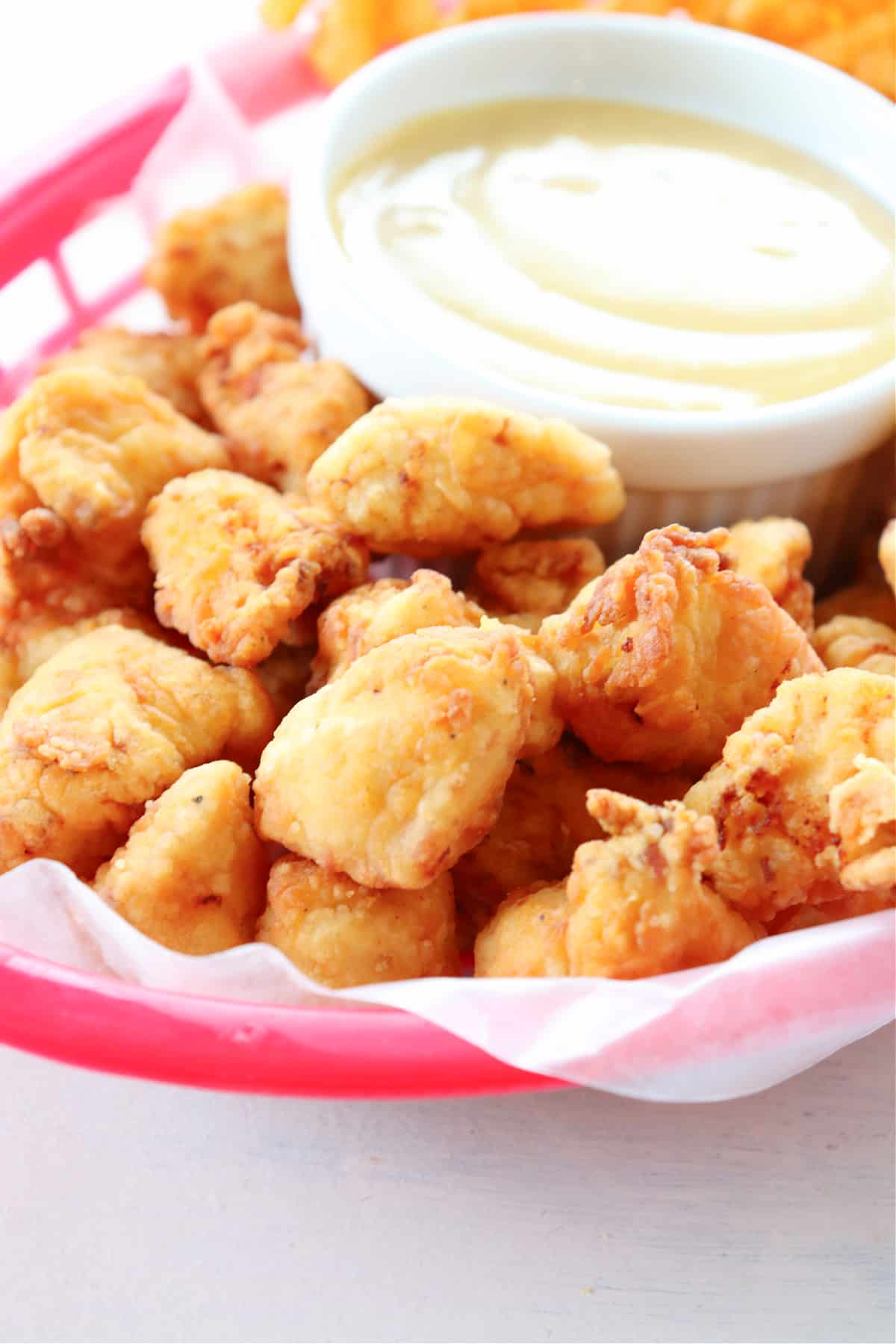 Chicken nuggets in red basket.