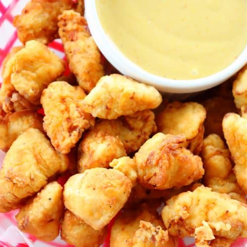 Chicken nuggets with dipping sauce in basket.