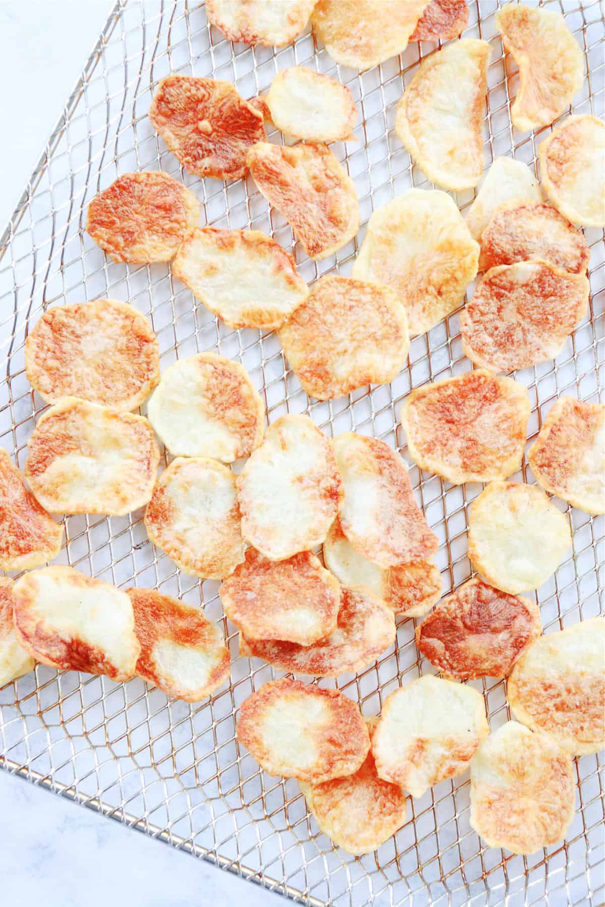 Potato chips on air fryer rack.