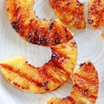 Grilled pineapple slices on a plate.