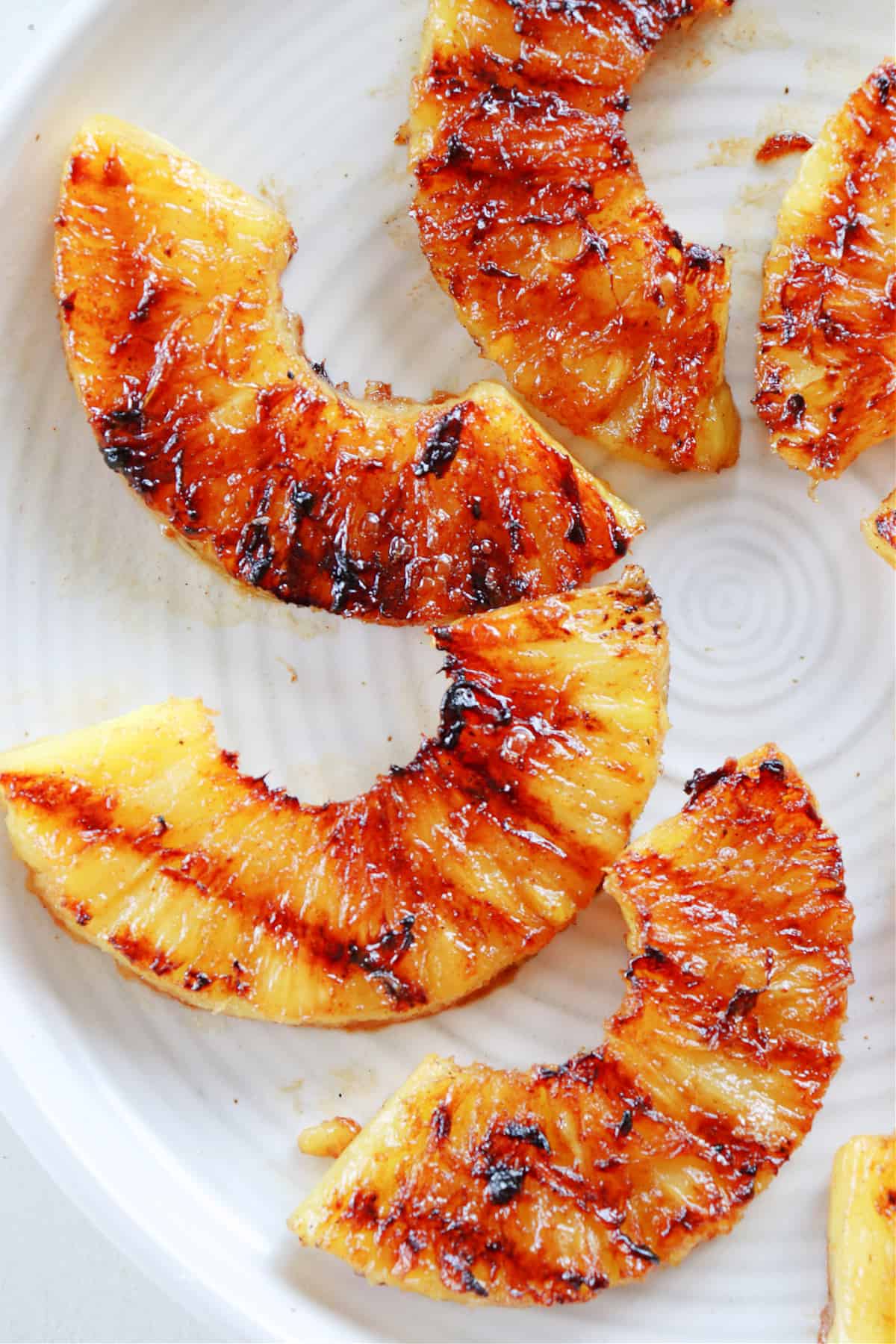 Grilled pineapple slices on a plate.