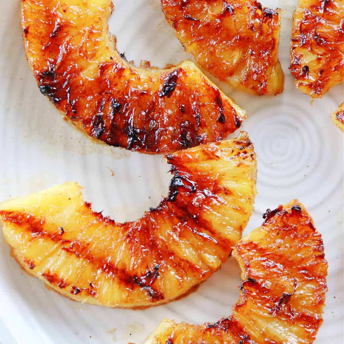 Slices of grilled pineapple on a plate.