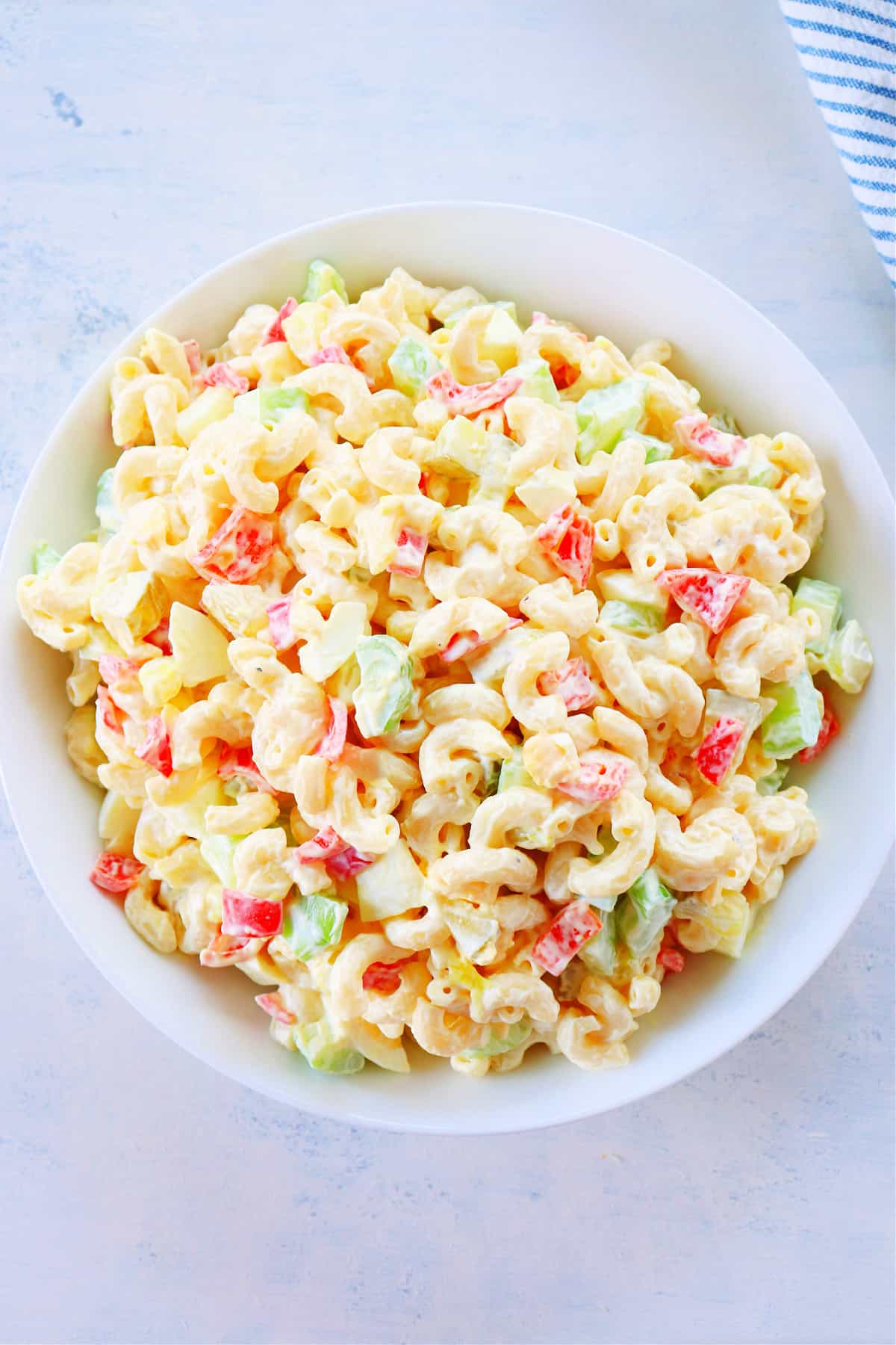 Macaroni salad in a white bowl.