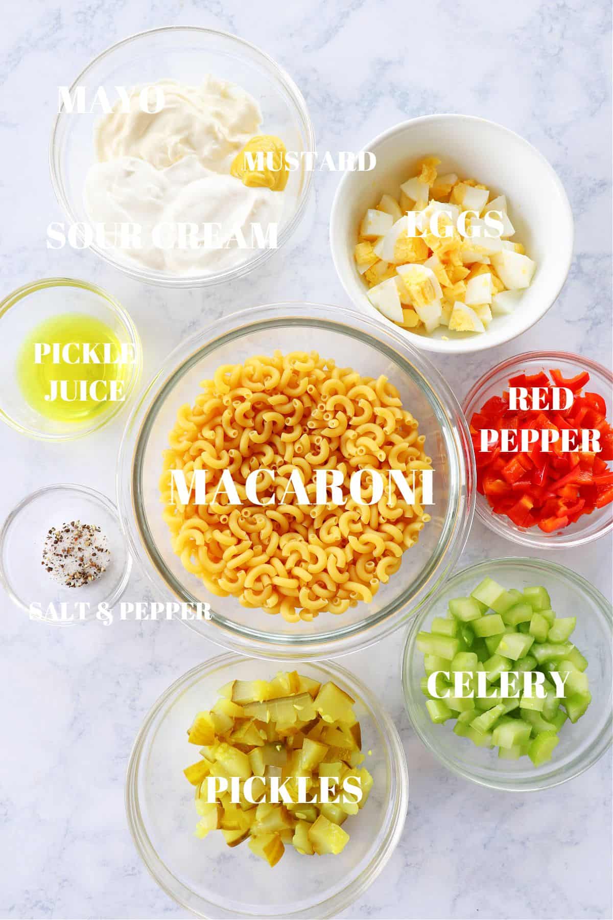 Ingredients for macaroni salad in small bowls on a board.