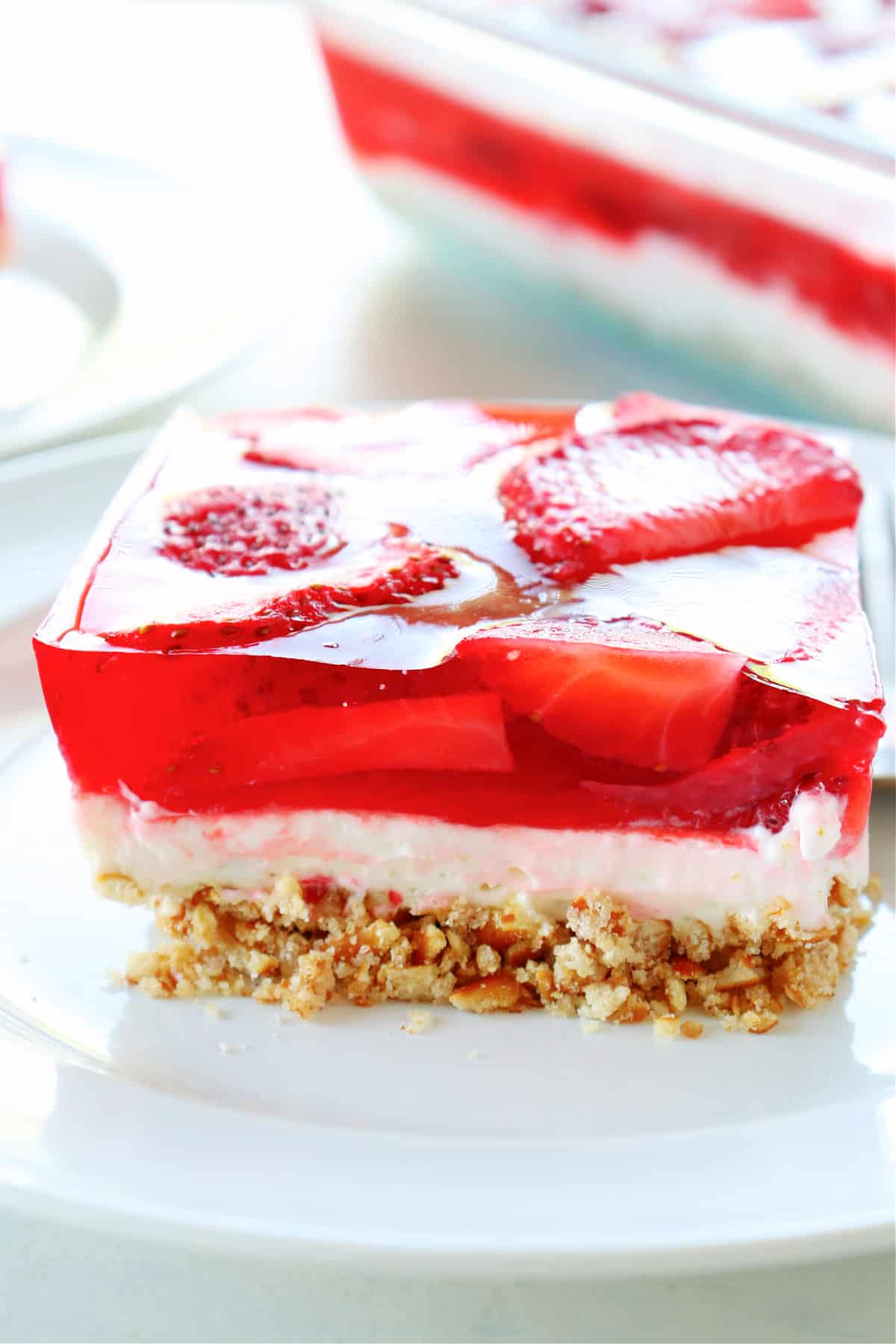 Square or strawberry pretzel salad on a plate.