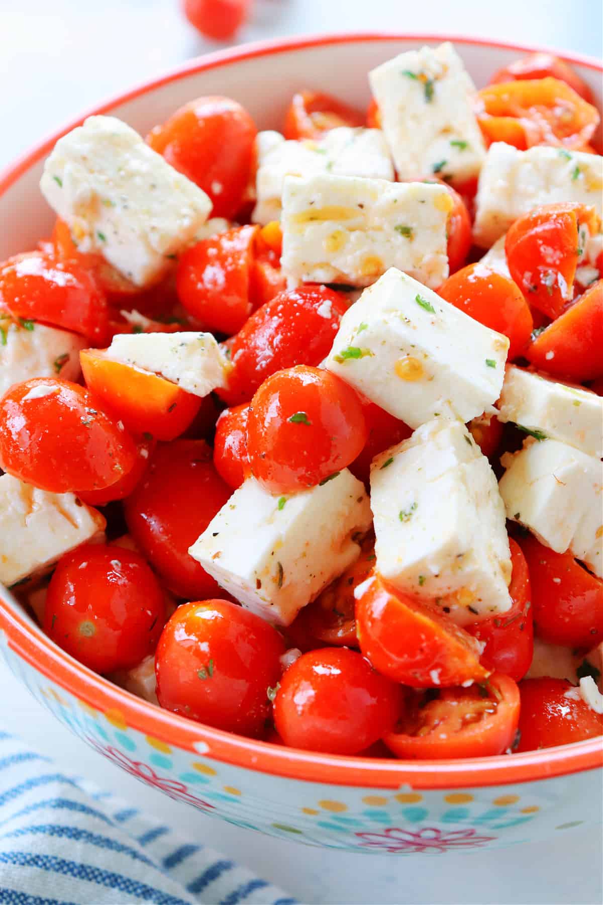 Close up shot on tomato feta salad in a ceramic bowl.