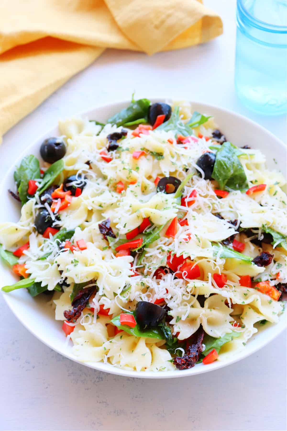 Pasta salad in a white bowl.