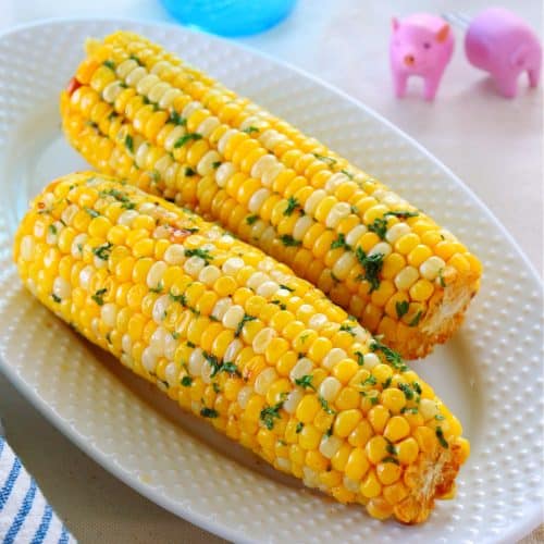 Cooked corn on a white plate.