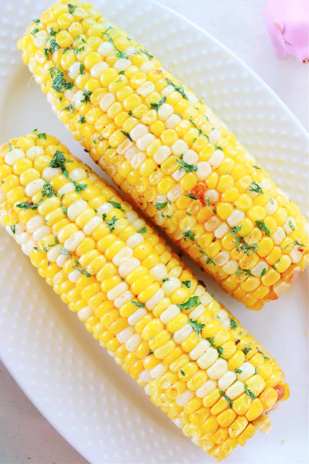 Air Fryer Corn on the Cob recipe Two cobs of corn on a plate.