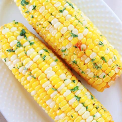 Corn on the cob on an oval plate.