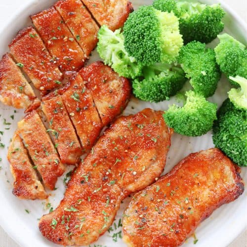 Pork chops and broccoli on a plate.