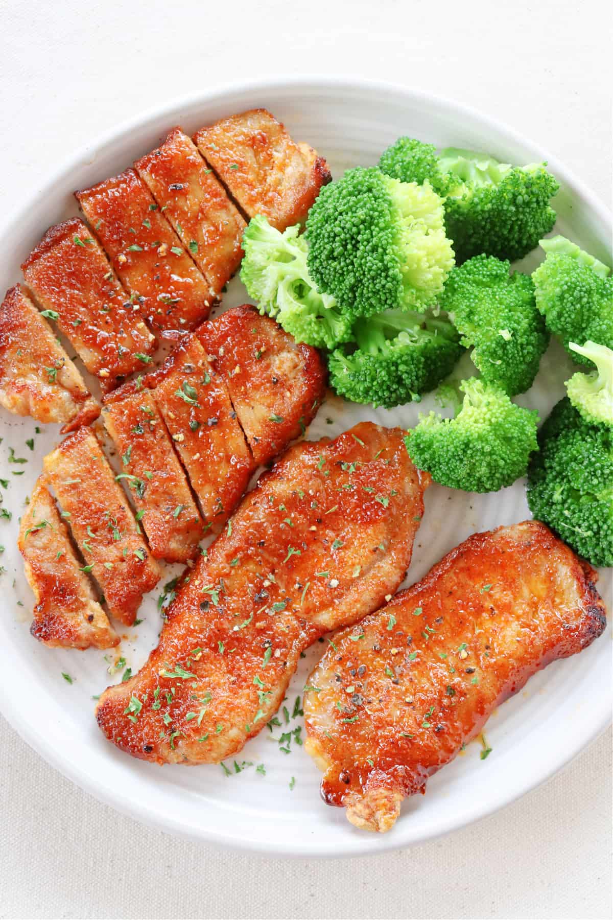 Pork chops and broccoli on a plate.