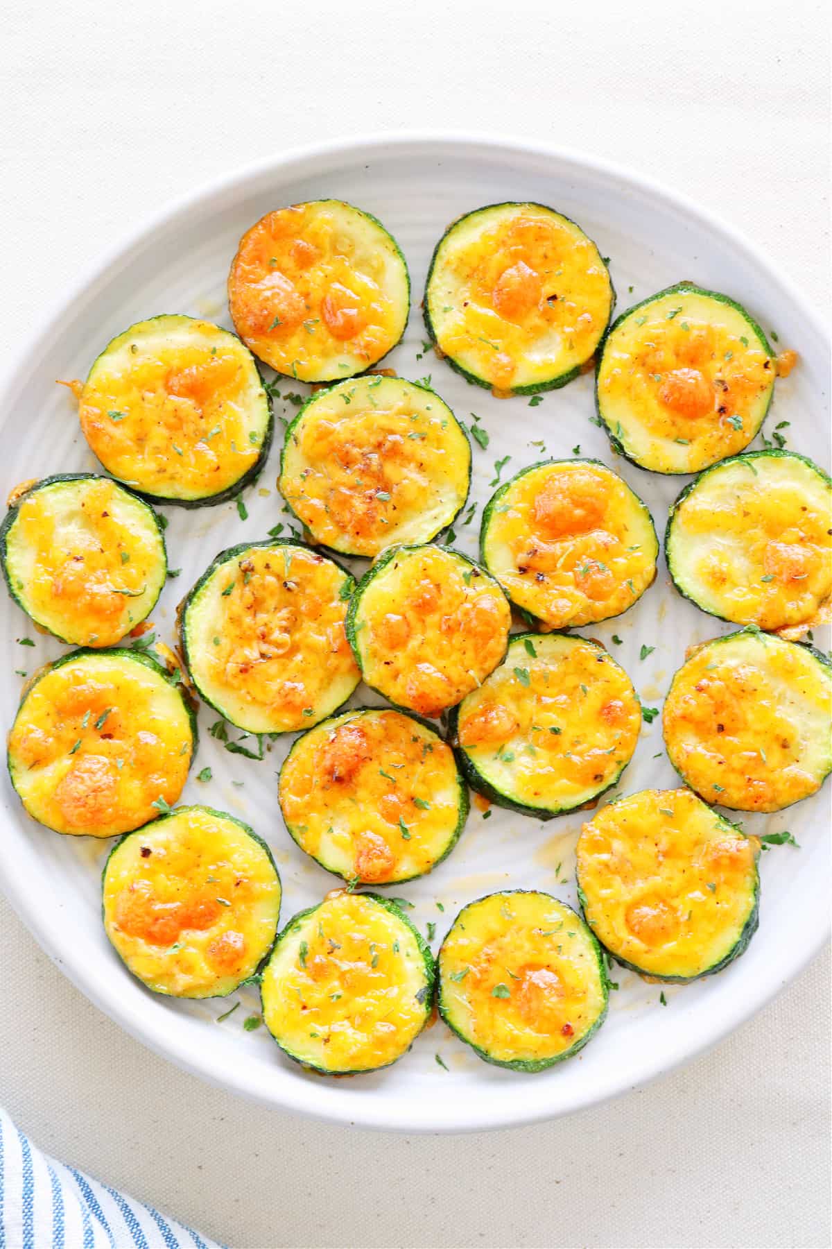 Zucchini with cheddar on a round plate.