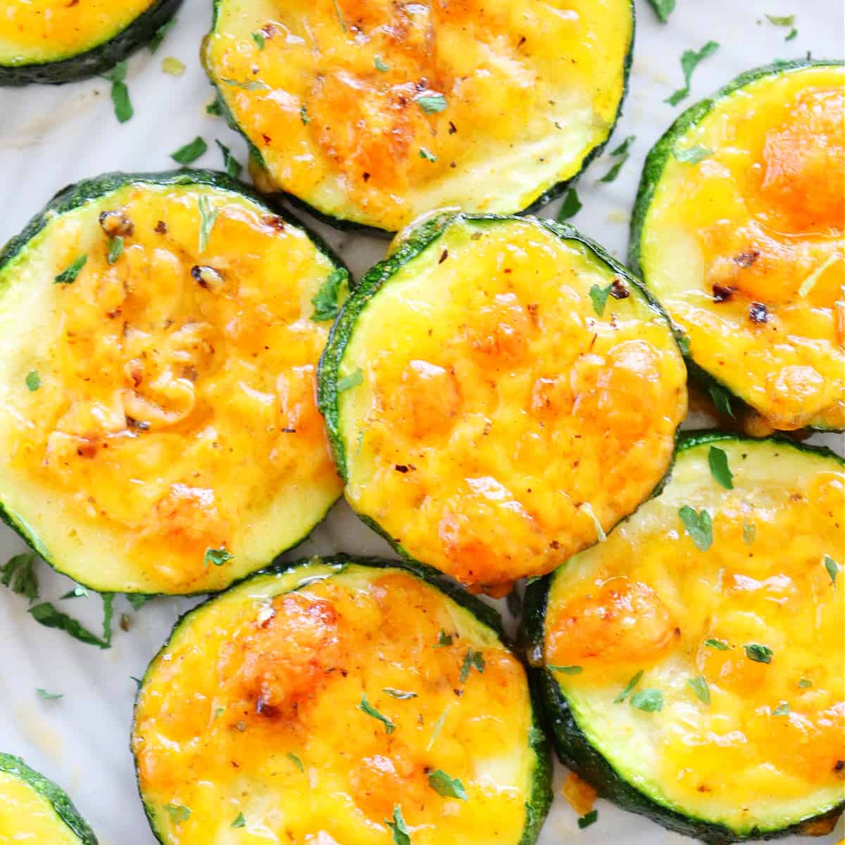 Baked zucchini slices on a white plate.